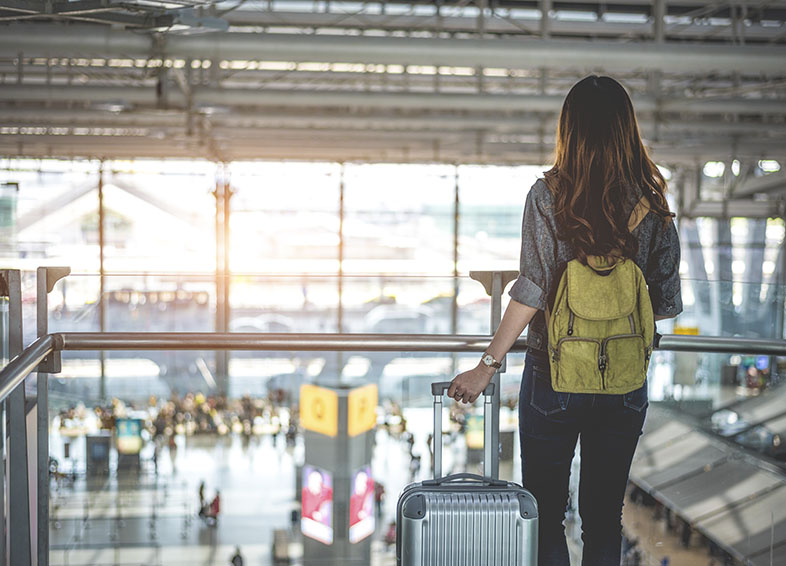 Mulher chegando ao aeroporto de destino após decidir morar fora do brasil