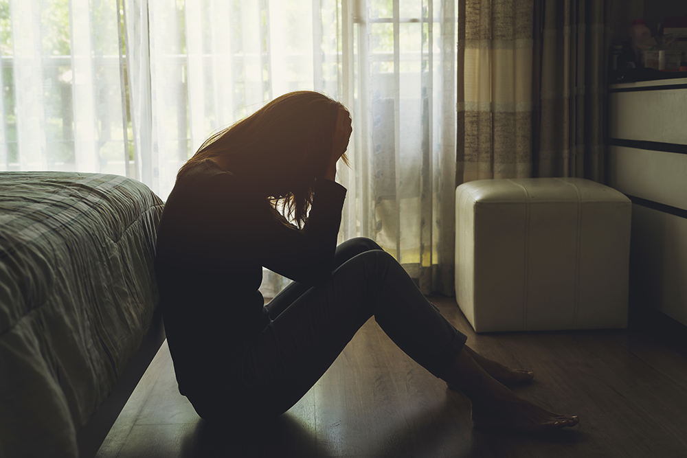 Mulher sentada no chão enquanto lida com o luto